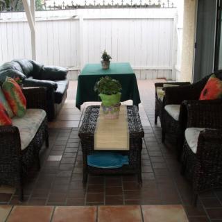 A cozy patio seating area with wicker furniture and colorful cushions.
