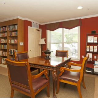 A cozy office meeting room with wooden furniture and bookshelves.