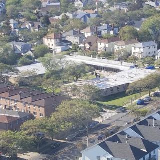 Aerial view of a suburban neighborhood featuring a mix of residential buildings and green landscapes.