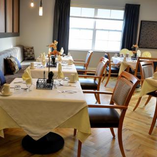 A well-arranged dining area with neatly set tables and comfortable chairs.