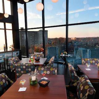 A beautifully designed restaurant with a stunning city view at sunset.