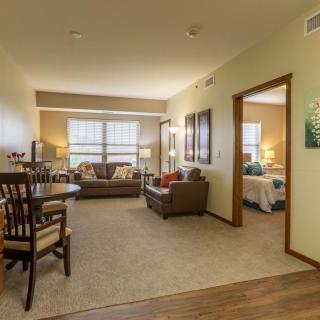A cozy apartment living room with a dining area, furnished with comfortable seating and ample natural light.