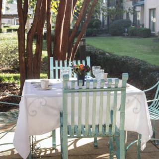 A sunlit garden patio with a table set for tea.