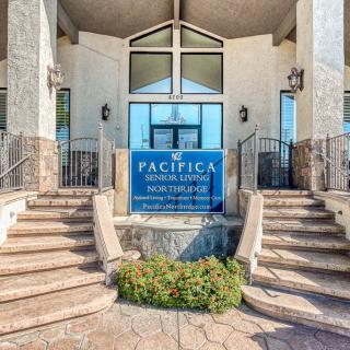 The entrance to Pacifica Senior Living, featuring a welcoming sign and elegant staircases.