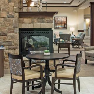 A cozy seating area with a round table and chairs near a stone fireplace.