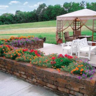 A beautifully landscaped garden featuring vibrant flowers and a cozy outdoor seating area.