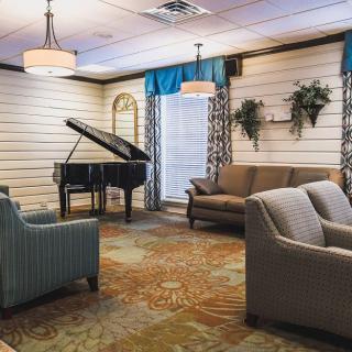 A cozy lounge area featuring a grand piano and comfortable seating.