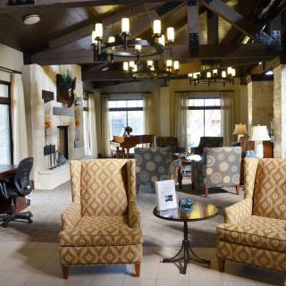 A spacious lounge area with comfortable seating and elegant chandeliers.