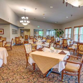 A spacious and elegantly decorated dining room with neatly arranged tables and chairs.