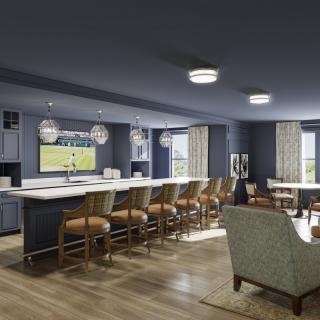 A modern open-concept kitchen and living area with a large island, bar stools, and stylish lighting fixtures.