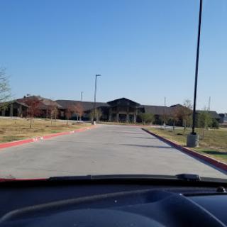View of a building from the perspective of a parked car on a clear day.