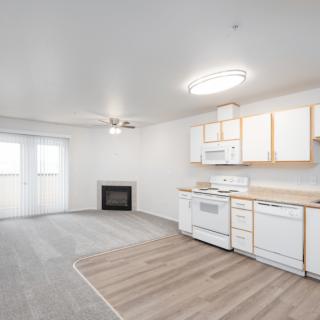 A modern open-space apartment featuring a kitchen and living area with minimalist decor.