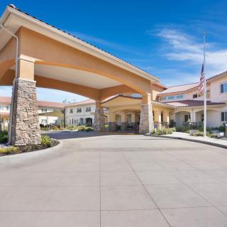 A residential building with a covered entrance and well-maintained landscaping.