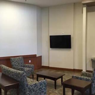 A cozy lounge with patterned chairs and a wall-mounted television.