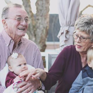 Grandparents enjoying time with their grandchildren outdoors.