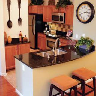 A modern kitchen with a sleek countertop, bar stools, and stylish decor.