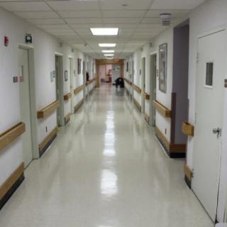 A clean and well-lit hospital corridor with multiple doors on either side.