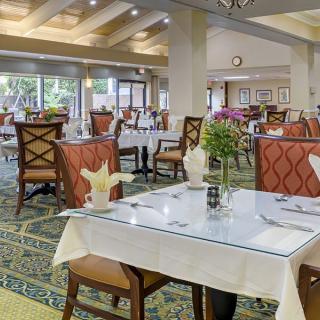 An elegant restaurant dining area with neatly arranged tables and chairs, featuring tasteful decor.