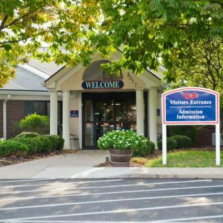 The image shows the entrance of a visitor center surrounded by greenery.