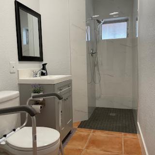 A modern bathroom featuring a glass shower, sleek sink, and minimalistic design.