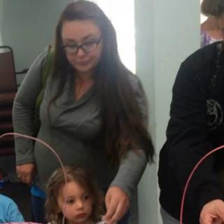 A woman and children participating in an indoor activity involving baskets.