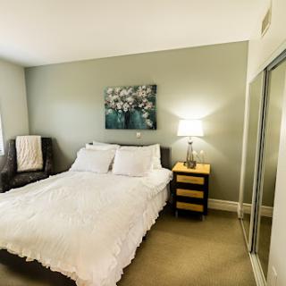 A cozy and inviting bedroom featuring a comfortable bed, stylish lamp, and decorative artwork.