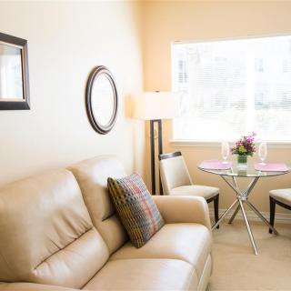 A cozy, modern living room with a beige sofa and round dining area.