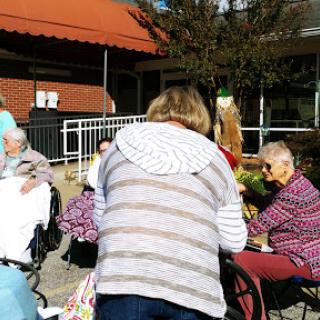 Residents enjoying a sunny day outside their care facility.