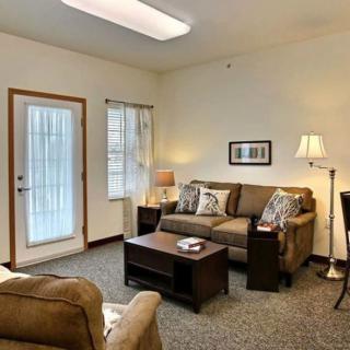 A cozy living room with a sofa, coffee table, and lamp.
