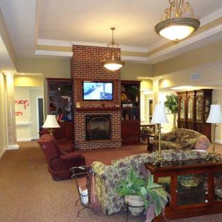 A cozy living room with a fireplace, comfortable sofas, and a television mounted above the mantel.