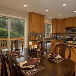 A cozy kitchen and dining area with wooden cabinets, a well-set dining table, and modern appliances.