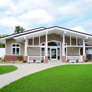 A modern residential house with a spacious front lawn and driveway.