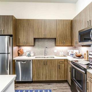 A modern kitchen with stainless steel appliances and wood cabinets.