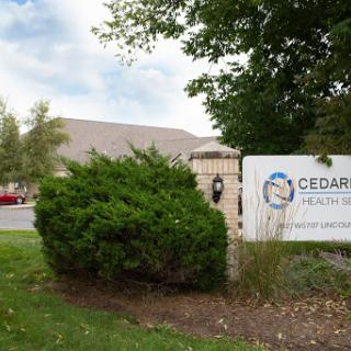 The entrance to Cedar Health, featuring clear signage and a landscaped area.