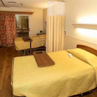 A hospital room with two beds separated by curtains, designed for patient care.