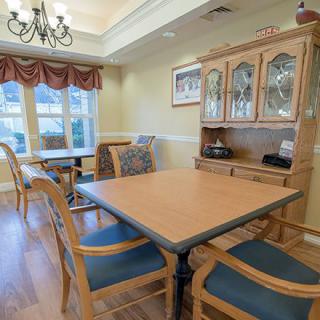A cozy dining area with wooden furniture and a decorative chandelier.