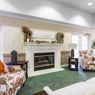 A cozy living room featuring a decorated fireplace and comfortable seating.