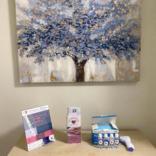 A cozy corner featuring a painting of a tree and assorted health products on display.