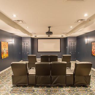A cozy home theater setup featuring comfortable seating and a large projector screen.