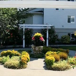 A well-maintained garden with vibrant flowers and lush greenery in front of a building.