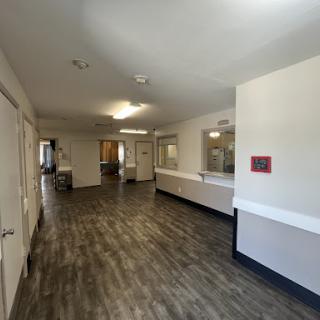 A spacious interior hallway with modern flooring and bright lighting.