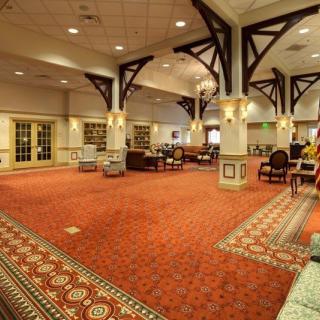 Spacious hotel lobby with red carpet and elegant decor.