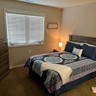 A cozy bedroom with a neatly made bed and a soft lamp glow.