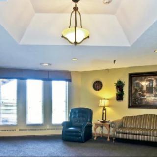 A cozy living room with a sofa, armchair, and decorative elements under soft lighting.