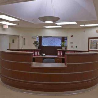 A view of a hospital reception desk in an empty waiting area.