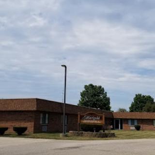 A brick school building under a cloudy sky.