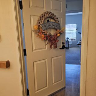 A warmly decorated door with a colorful wreath, inviting guests into the home.