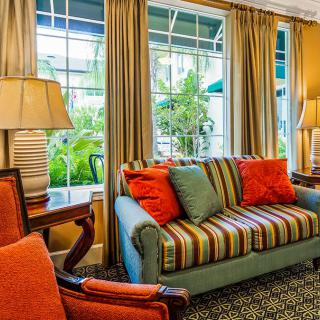 A cozy, well-lit living room with a striped sofa and vibrant cushions.