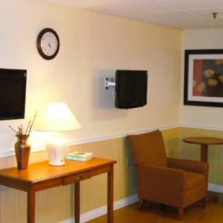A cozy living room with a chair, table, lamp, and artwork on the wall.