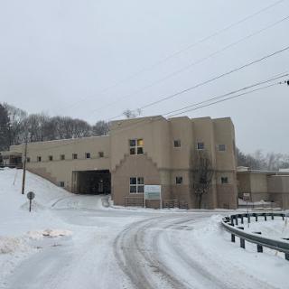 A winter scene featuring a uniquely designed building surrounded by snow-covered ground.